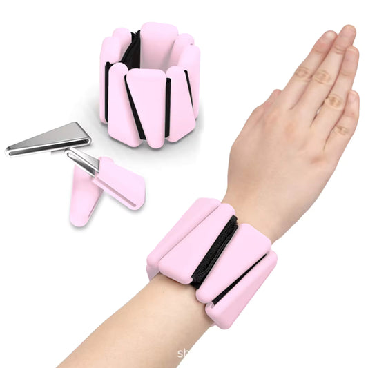 Pink wrist and ankle weights with adjustable straps on a white background